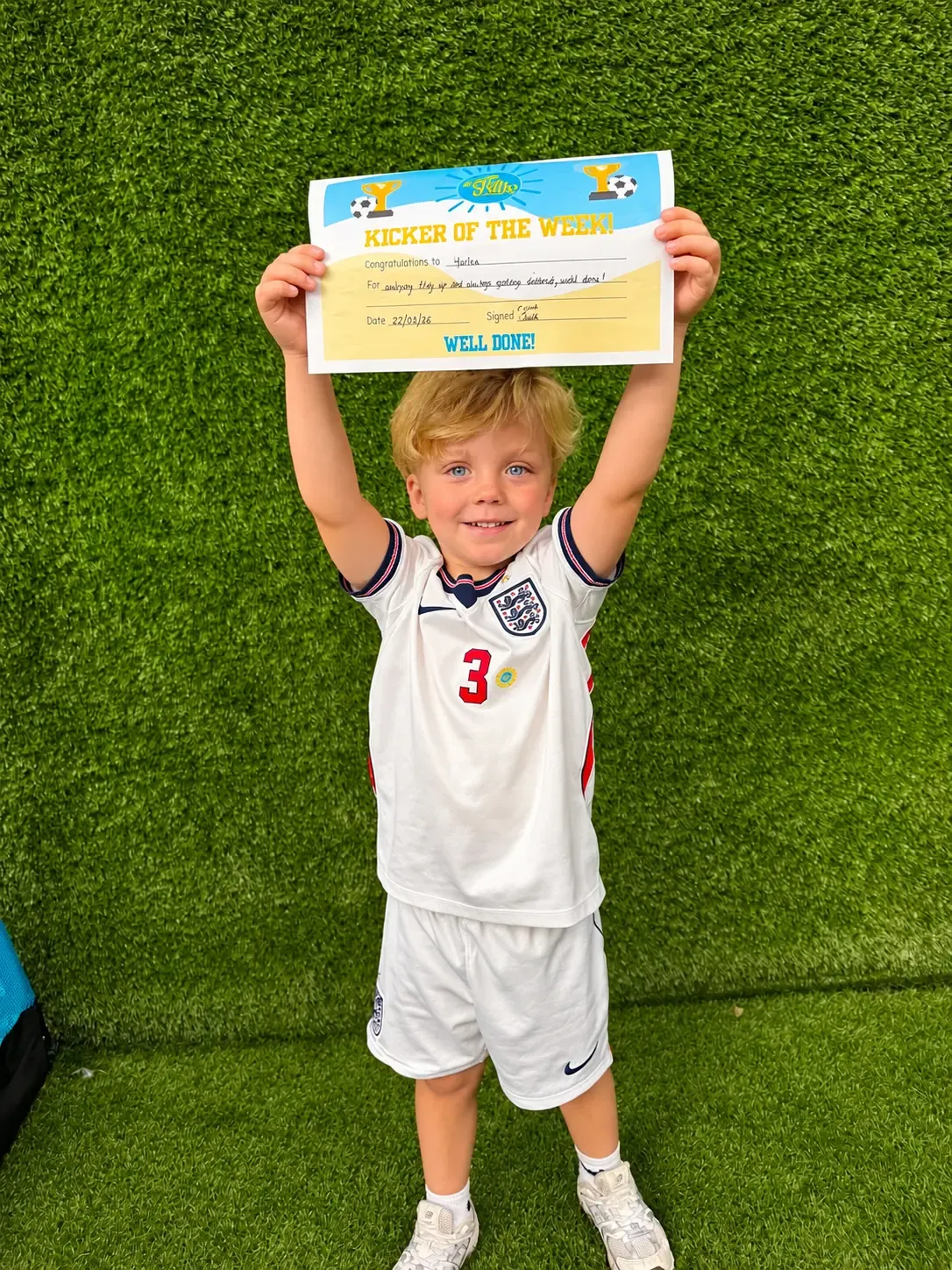 Child celebrating receiving a Kicker of the Week certificate at Ickle Skills